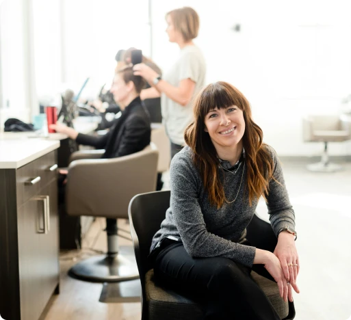 une femme qui sourit dans un salon de coiffure