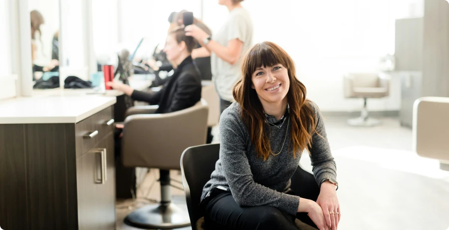 une femme qui sourit dans un salon de coiffure