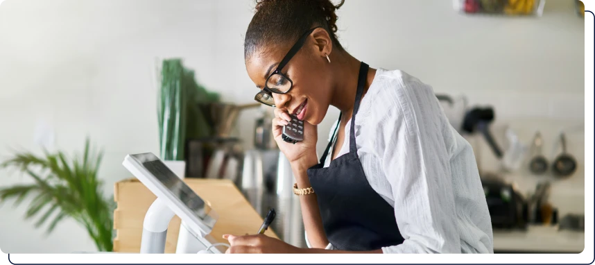 une femme qui est au téléphone et qui écrit