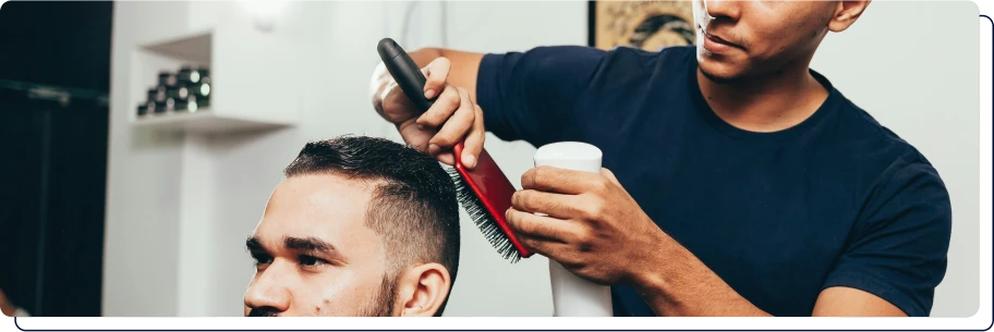 un coiffeur qui coupe les cheveux d'un homme