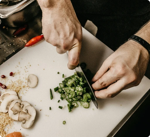 les mains d'un cuisiner qui coupe des légumes