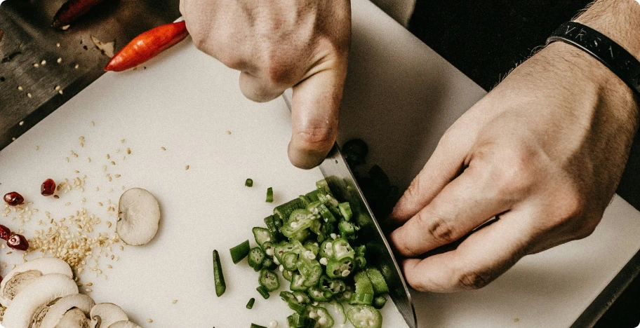 les mains d'un cuisiner qui coupe des légumes