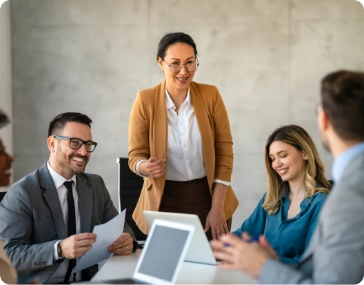 Femme en discussion avec deux collègues dans un environnement professionnel